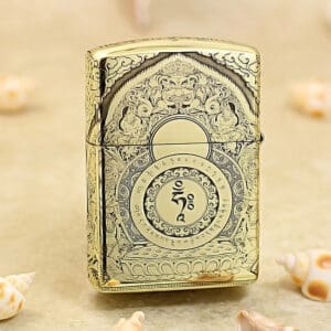 Ornate gold lighter with intricate engravings and a central circular motif, standing on a beige surface.