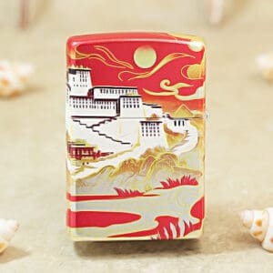 Decorative lighter with a red top featuring a white hillside town, mountains, and a sun motif in gold and white accents.