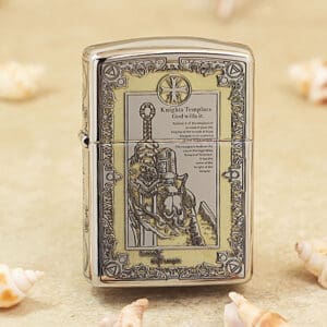 Metal lighter with an ornate Knights Templar engraving and decorative border on a beige surface