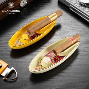 Two decorative boat-shaped cigar trays with colorful patterned interiors, each holding a cigar, visible with a lighter and accessories nearby; brand logo CIGARLOONG in the top left.