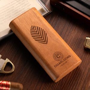 Wooden cigar humidor box with a leaf logo and 'CIGARLOONG' branding on a dark wood table surrounded by cigar accessories.